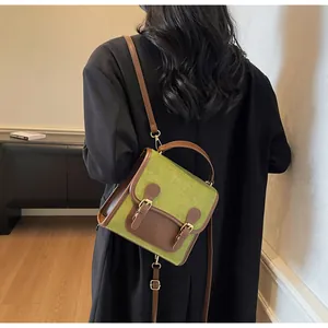 Detail of vintage avocado green crossbody bag with brown trim and double buckle closure