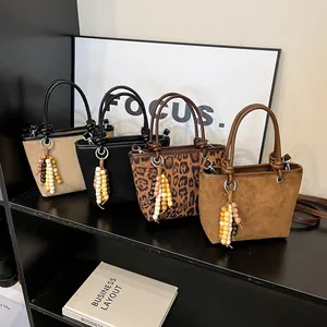 Suede leopard print bucket bag and neutral tote bag collection with beaded charms