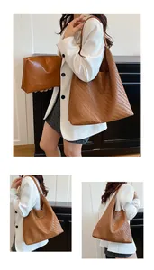 Detail of brown woven tote bag showing Intrecciato texture and small inner zipper pouch