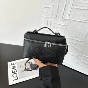 Sac bandoulière minimaliste en cuir noir avec zips argentés et poignée supérieure