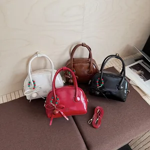 Sacs boston en cuir verni brillant en quatre couleurs avec charmes de nœud et bandoulières