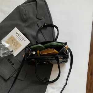 Chic black PU leather tote bag with gold hardware shown with daily essentials