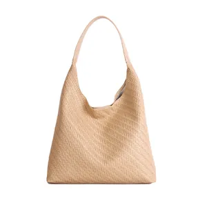 Beige woven bucket tote bag with wide shoulder strap in minimalist hobo style for women