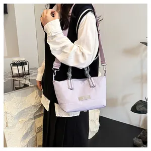 Detail of light purple nylon tote bag with woven handle and broad adjustable shoulder strap