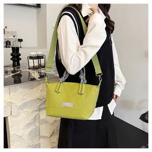 Detail of green nylon shoulder bag with adjustable strap and woven knot handle