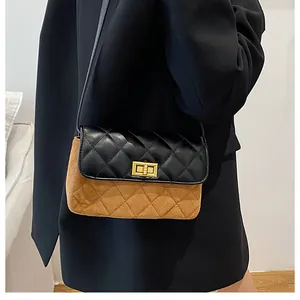 Detailansicht der zweifarbigen Stepptasche mit goldenem Metall-Drehverschluss