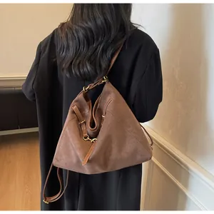 Detail of vintage brown suede tote bag with bronze metal buckles and drawstring side