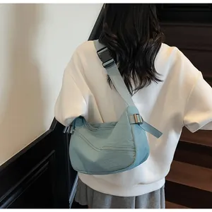 Detail of light blue nylon crescent bag with adjustable wide strap and plastic buckle