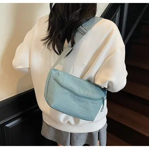 Light blue nylon crossbody bag shown worn by a model to display size and drape details