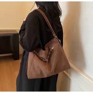 Detailed view of vintage large-capacity shoulder bag in brown faux suede with gold buckles