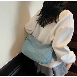 Detailed side view of a light blue nylon crossbody bag shown on a model on stairs