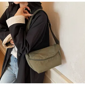 Close-up of olive green nylon crossbody bag showing water-resistant fabric and zippers