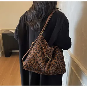 Detail of leopard print tote bag with brown leather straps and gold metal buckle details