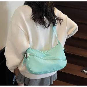 Detail showing mint green canvas crossbody bag with adjustable strap and zipper pocket