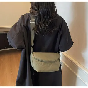 Detailed close-up of olive nylon messenger bag strap with adjustable metal buckle