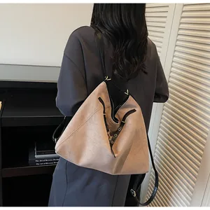 Detail showing camel suede texture and metal ring buckle on the versatile shoulder bag
