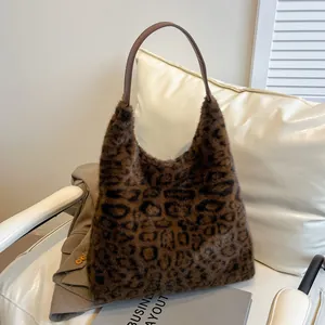 Faux fur leopard print tote bag with brown leather handles on a minimalist armchair