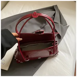 Detail of dark red crocodile pattern bag with silver studs and inner zipper pocket