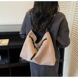 Macro view of matte light brown tote bag with black leather straps and metal hardware