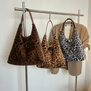 Faux fur leopard print tote bags in three colors with leather straps on a display rack