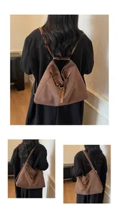 Detail of dark brown suede shoulder bag showing matte texture and adjustable metal eyelets