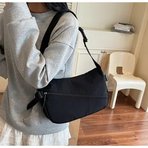 Detail of black crossbody bag featuring durable nylon fabric and adjustable wide strap