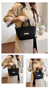 Detail of black nylon tote with striped knot handles and adjustable crossbody strap