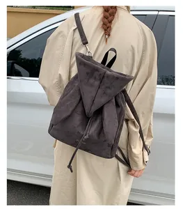 Détail du sac à dos en daim gris avec oreilles de lapin décoratives sur un modèle