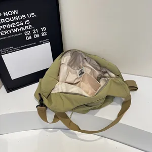 Olive green nylon dumpling crossbody bag with spacious interior and adjustable strap