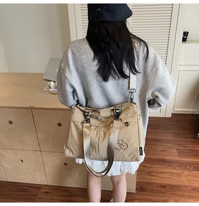 Detailed back view of a khaki oversized nylon crossbody bag with side woven label