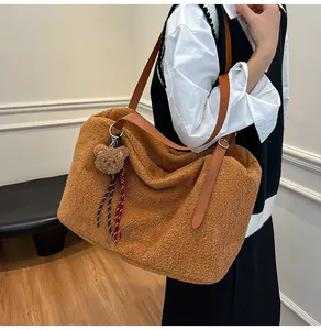 Detail of a fluffy brown tote bag with leather strap and cute bear charm accessory