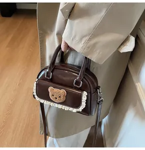 Detail der dunkelbraunen Mini-Tasche mit Plüschbär, Spitze und Reißverschluss