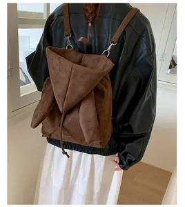 Détail du design d'oreilles de lapin sur sac à dos en daim marron avec bretelles