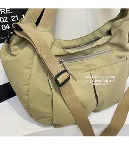 Detailed shot of adjustable wide nylon shoulder strap with matte buckle on dumpling bag