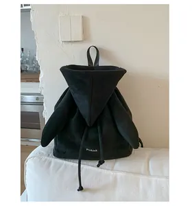 Détail d'un sac à dos en velours noir avec ailes d'ange et broderie logo blanc
