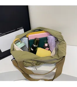 Spacious interior of the olive green nylon crossbody bag filled with daily essentials