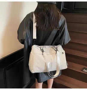 Detail showing high capacity tote bag with wide shoulder strap on wooden stairs