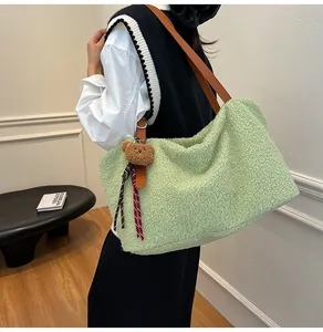 Detail of light green plush tote bag featuring brown leather handles and bear charm