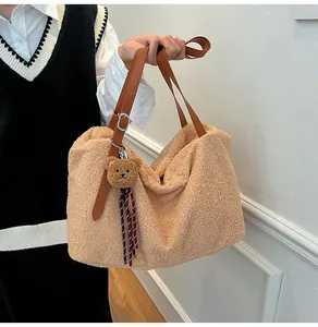 Detail of khaki faux shearling tote bag with brown leather handles and a cute bear charm