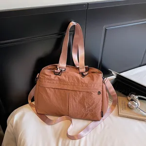Close-up of minimalist dusty rose tote bag with dual rings logo and side zipper detail