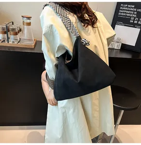 Sac hobo noir avec bandoulière à rayures noires et blanches et détail de nœud
