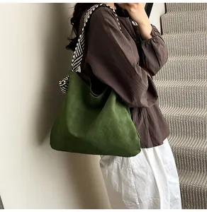 Détail du sac cabas matelassé vert foncé avec bandoulière rayée motif zèbre noir et blanc