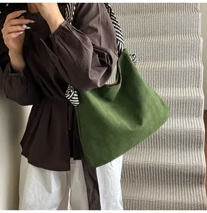 Détail du sac hobo vert avec texture gaufrée et bandoulière tissée sur un mannequin