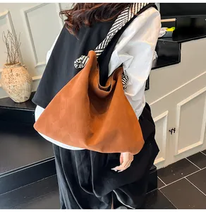 Détail du sac matelassé caramel avec des bretelles rayées noires et blanches tendance