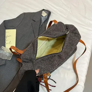Gray plush faux fur tote bag with brown leather handles and spacious interior pocket