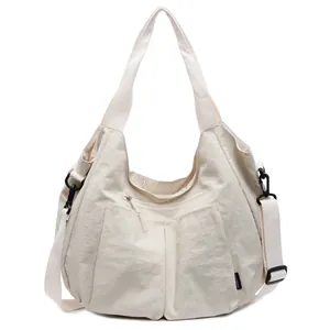 Minimalist beige nylon dumpling hobo bag with multi-pocket design and adjustable strap