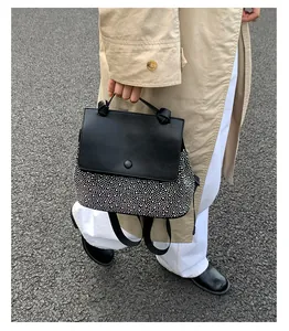 Detail of a chic black and white contrast backpack with silver stud accents and handle