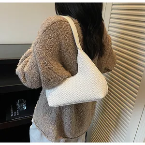 Vue détaillée du sac porté épaule blanc tressé en forme de croissant sur un mannequin