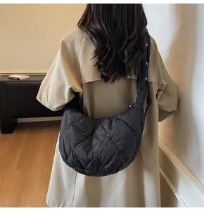 Détail du sac croissant noir matelassé avec surpiqûres en cœur et bandoulière large