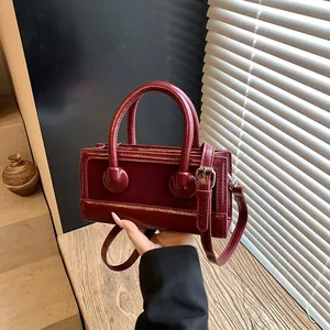 Deep wine red rectangular box handbag with dual textures and round decorative buckles